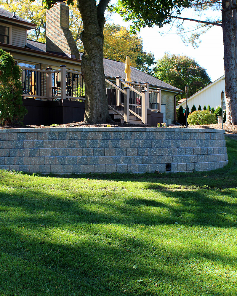 a tall block retaining wall with grass in foreground